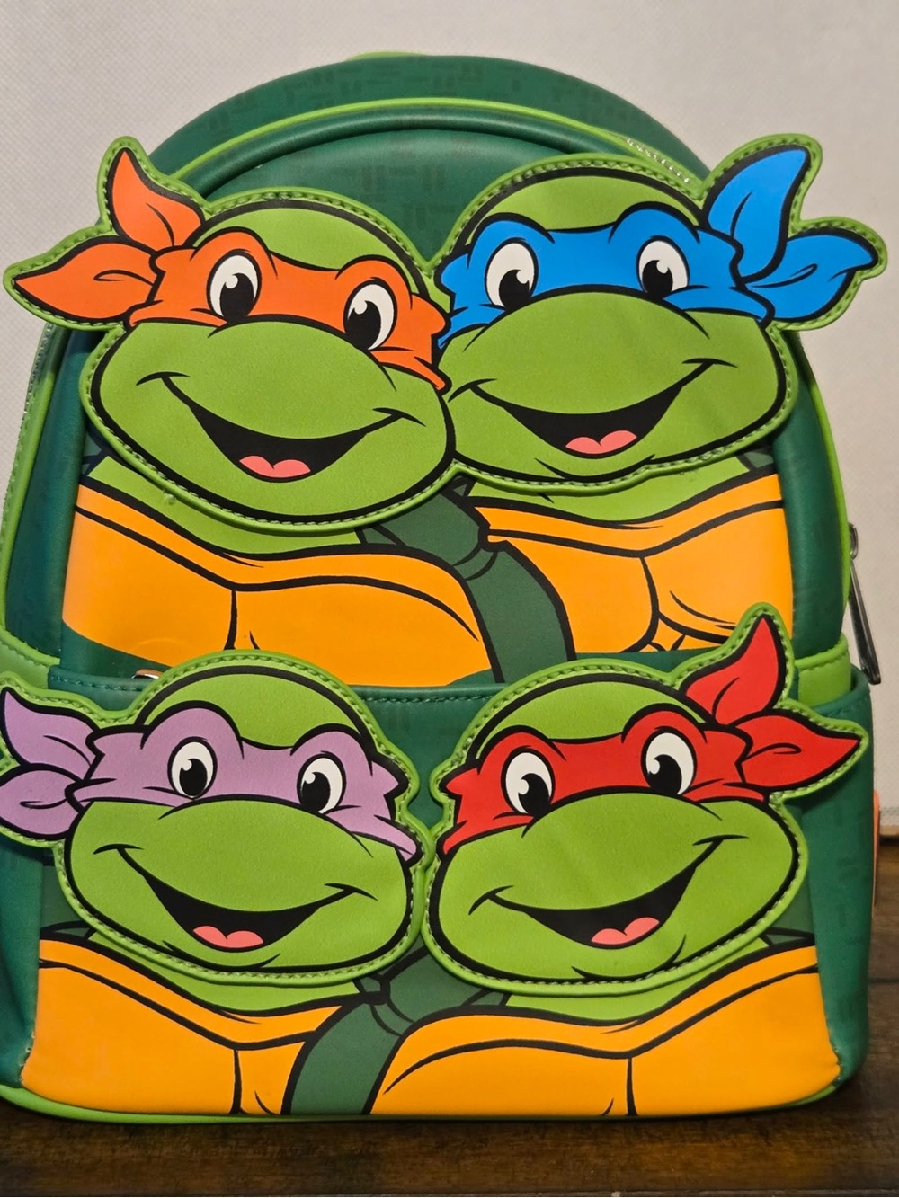 Loungefly Teenage Mutant Ninja Turtles Green Backpack with Colorful Masks